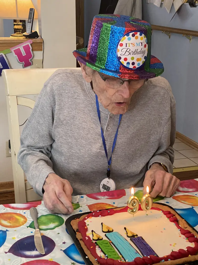 Resident in a sparkly birthday hat with his cake