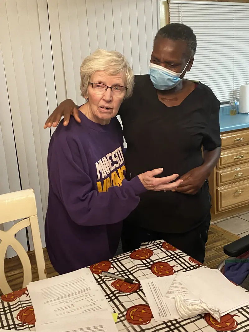 Caregiver with her arm around a resident in a Minnesota Vikings sweatshirt