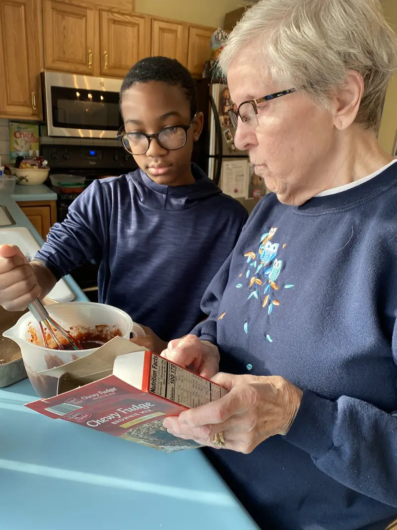 Resident and a young helper preparing food
