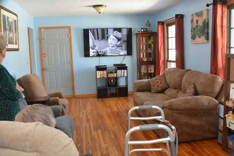 Bright living room with recliners and a television at Beyond Senior Living
