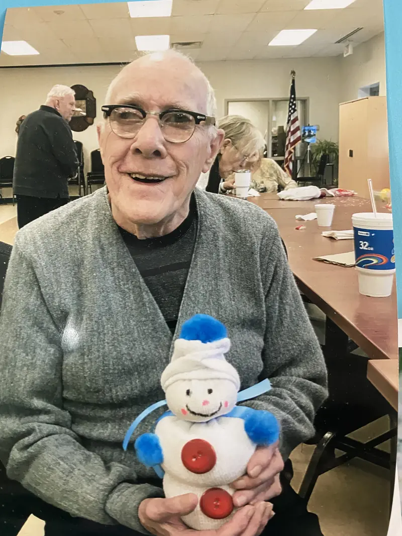 Resident smiling with a snowman decoration