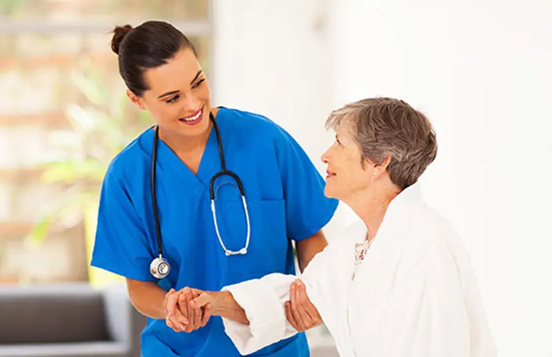 Nurse holding hands with an older woman