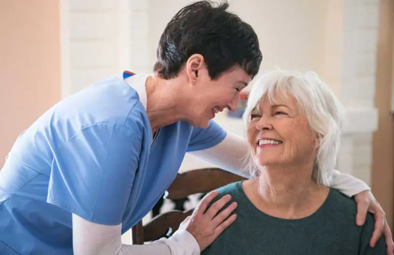 Caregiver sharing a warm moment with an older woman