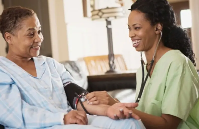 Nurse taking an older woman’s blood pressure